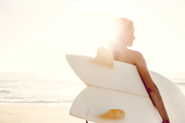 Mulher com prancha de surf após um dia de surf — Fotografia de Stock