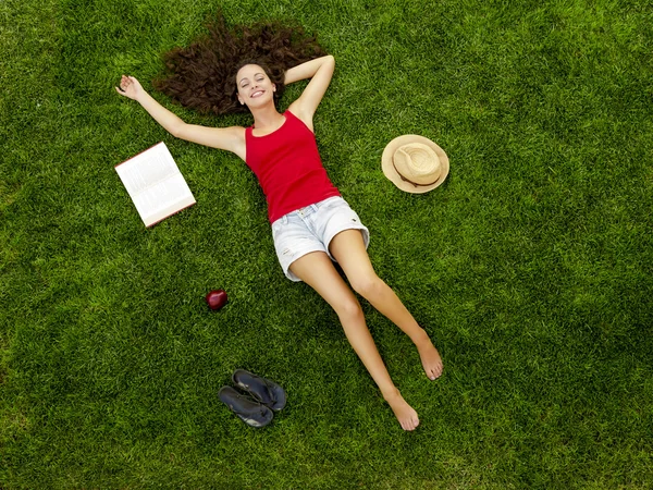 Mujer joven acostada en la hierba — Foto de Stock