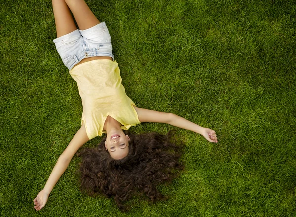 Mujer joven acostada en la hierba — Foto de Stock