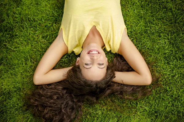 Jeune femme allongée sur l'herbe — Photo