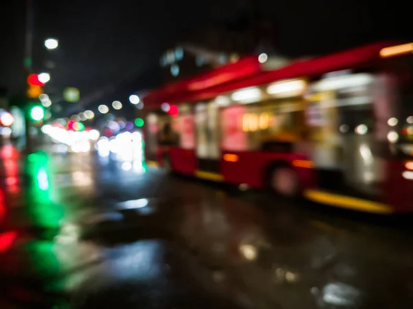 Defocused natt regn stad gata vy med röd buss korsning väg — Stockfoto