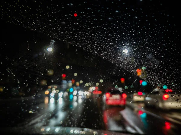 Foto desfocada da visão do motorista da noite na cidade do carro de direção direita — Fotografia de Stock