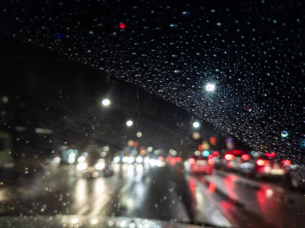 Photo déconcentrée de la vue du conducteur de nuit sur la ville depuis la voiture de direction droite — Photo