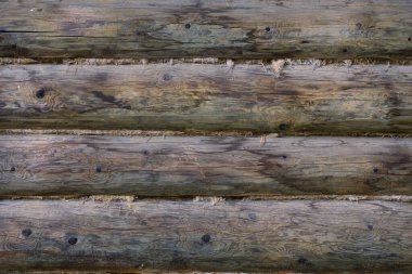 kirişler arasında keten conta olan gri yuvarlak ahşap duvar