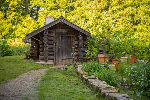 模糊的花园背景和旧的黑色木制谷仓 — 图库照片
