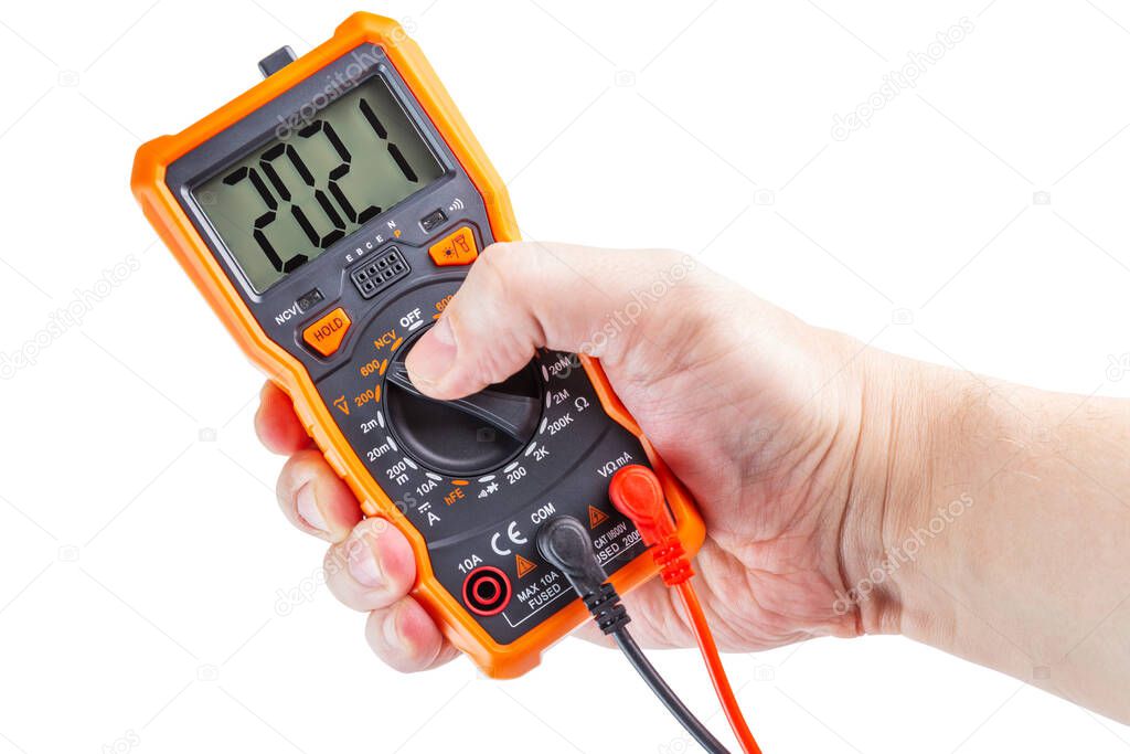 digit 2021 on lcd screen of digital electrical multimeter in left caucasian hand, isolated on white background