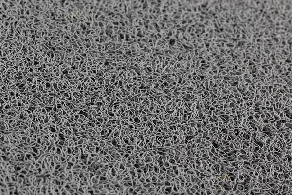 abstract gray background of rubber hair synthetic welcome mat with selective focus and blur.