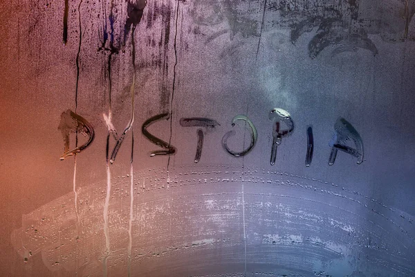 The word dystopia handwritten on wet window glass surface — Stock Photo, Image
