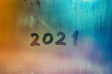 Islak gece penceresi yüzeyinde el yazısıyla 2021 rakamı