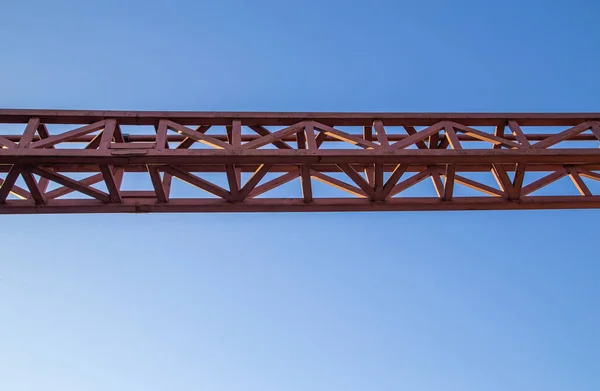 straight red steel welded truss on blue sky background