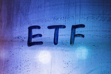 Kısaca etf - değiş tokuş fonları - sisli cam pencereye geceleri neon mavisi arka sokak lambasıyla el yazısıyla yazılmıştır