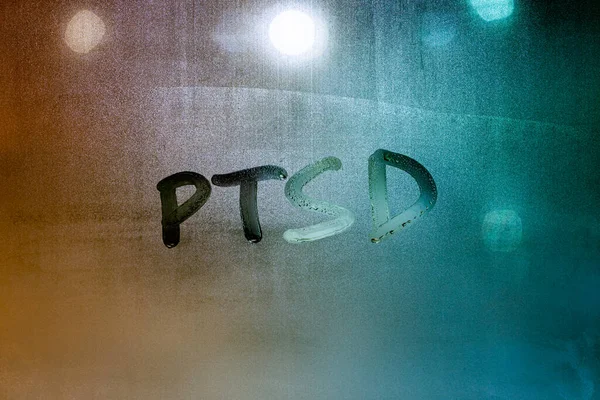 Skrót PTSD - zespół stresu pourazowego - odręcznie pisany na mokrej szklance okna nocnego — Zdjęcie stockowe