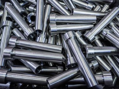 pile of shiny steel tubes after cnc turning operations - abstract full frame indistrial background clipart