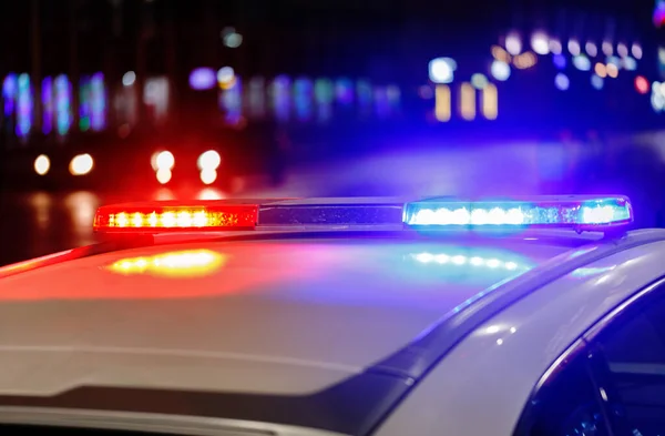 Luces del coche de policía por la noche en la ciudad con enfoque selectivo y bokeh — Foto de Stock