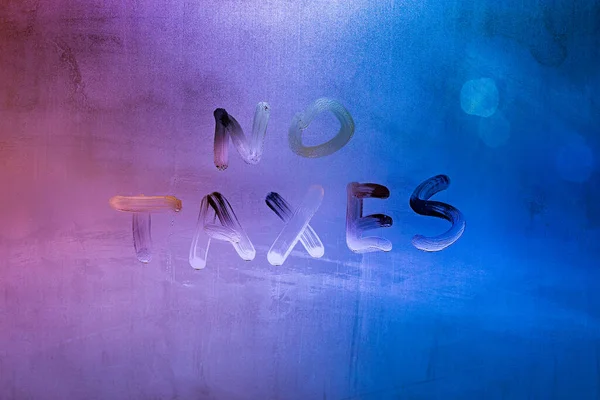 Worte keine Steuern handgeschrieben auf nächtlicher nasser Fensterglasfläche — Stockfoto