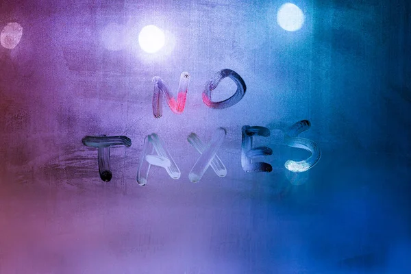 Slova žádné daně ručně psané na noční mokré okno skleněný povrch — Stock fotografie