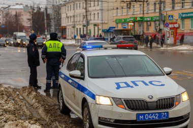 TULA, RUSSIA - 23 Ocak 2021: Rus karayolu polisi kış yolunda devriye arabasının yanında duruyor - çatı lambasına özenle odaklanmış yakın plan.