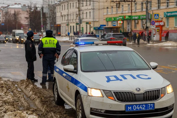 TULA, RUSSIA - JANUARY 23, 2021: російські дорожні поліцейські стоять біля патрульної машини на зимовій дорозі - зблизька з вибірковим фокусом на даховій лампі. — стокове фото