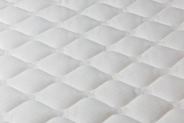 Seçici odaklı yumuşak beyaz yatak yakın plan.