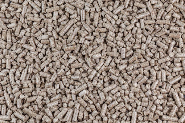 Pellets de serragem de madeira comprimido textura plana e fundo. Biocombustível e ninhada para animais de estimação, cobertura vegetal. — Fotografia de Stock