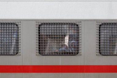 Rus Ulusal Muhafız Subayı, çevik kuvvet polis kamyonunun camında metal ızgaranın arkasında.