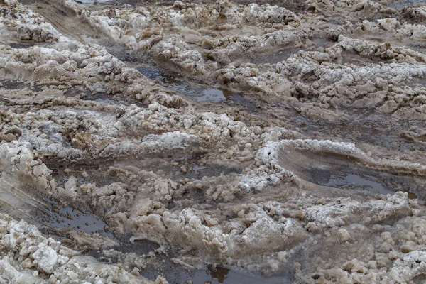 Dicke schmutzige nasse Schneeschicht mit Autoradspuren auf der Winterstraße - Vollrahmenhintergrund — Stockfoto