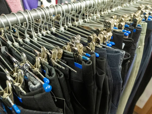 Ряд вішалок з дешевими штанами в магазині на ринку. Крупним планом з вибірковим фокусом . — стокове фото