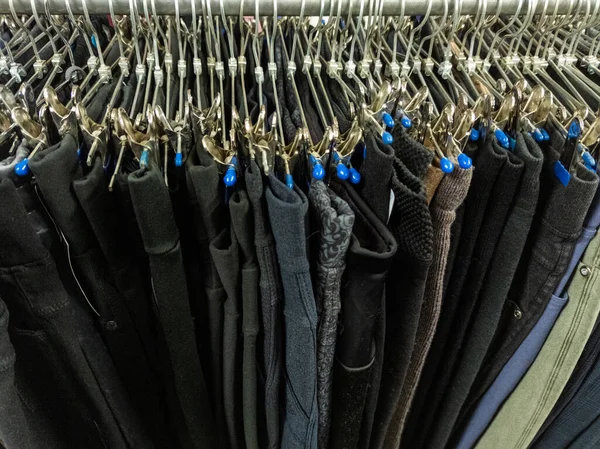 Ряд вішалок з дешевими штанами в магазині на ринку. Крупним планом з вибірковим фокусом . — стокове фото
