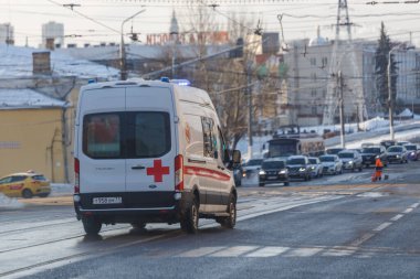 Beyaz ambulans minibüsü kışın ıslak caddede.