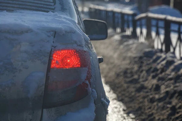 Luz trasera del coche sucio con nieve en la noche de invierno, primer plano con enfoque selectivo — Foto de Stock