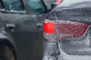 Kış akşamları kar ile kaplı buzlu araba stop lambası, seçici bir odaklanma ile yakın plan.