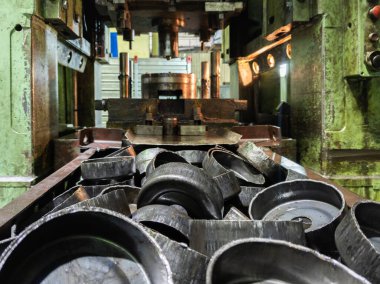 Bir kaput operasyonundan sonra basını oluşturan ölüm teçhizatının önünde kalın siyah metal parçaları yığını.