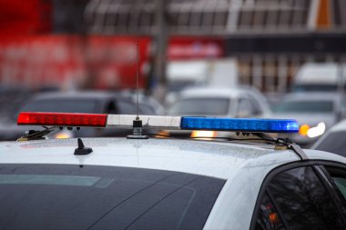 Kış günü şehir caddesinde polis arabası ışıkları. Arka planda bulanık arabalar var.