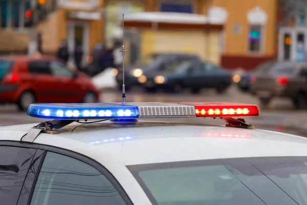 Feux de voiture de police dans la rue de la ville le jour d'hiver avec la circulation des voitures en arrière-plan flou — Photo