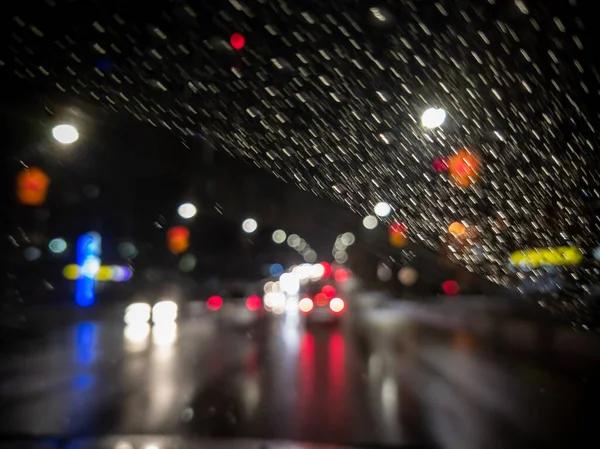 Foto desfocada da visão do motorista da noite na cidade do carro de direção direita — Fotografia de Stock