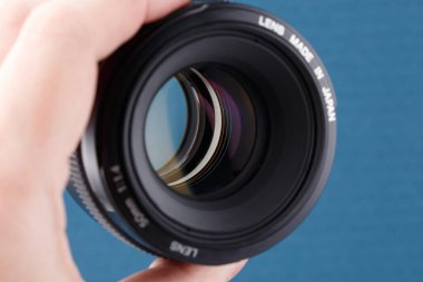 Mavi zemin üzerinde modern dijital 50 mm f 1.4 dslr lens - seçici odaklı yakın plan