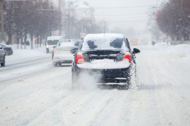 Kirli araba tekerleklerinden gelen kar parçaları seçici bir odak ile gün ışığında hızlı hareket ediyor..