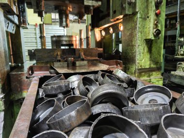 Bir kaput operasyonundan sonra basını oluşturan ölüm teçhizatının önünde kalın siyah metal parçaları yığını.