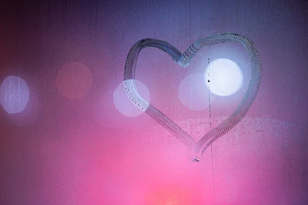 Simbolo del cuore disegnato a mano sul vetro finestra bagnato notte in colori rosa — Foto Stock