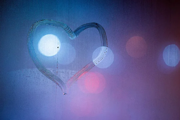 Simbolo del cuore disegnato a mano sul vetro finestra bagnato notte in colori blu — Foto Stock
