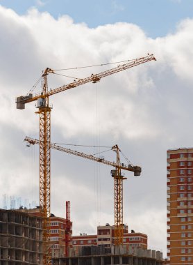 Bulutlu arka planda vinci olan büyük bir apartman binası inşa süreci