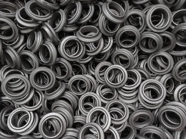 heap of grey steel ring forgings after shot blasting - close-up natural heavy industrial pattern with selective focus