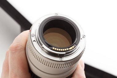 El ele tutuşan eski beyaz telefoto lensleri görünür süngü ve arka elementlerle