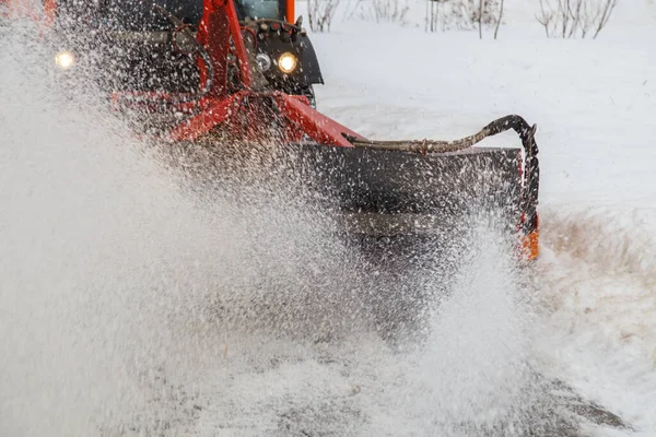 Limpieza de nieve. Eliminación de nieve tractor limpiando nieve del pavimento con cepillo de hilado redondo especial, — Foto de Stock