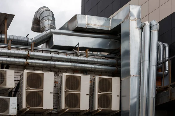 old outdoor ventilation air ducts and air conditioners outside of back wall of cafe kitchen