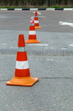 Kuru gri asfalt yol yüzeyindeki turuncu trafik konileri - seçici odaklı yakın plan