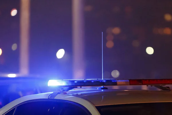 Поліцейські автомобільні вогні вночі в місті з вибірковим фокусом і боке — стокове фото