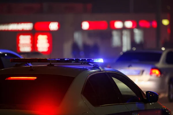 Niebieski samochód policyjny światło w nocy w mieście z selektywnym ostrością i bokeh na czarnym tle — Zdjęcie stockowe