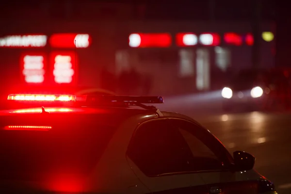 Luce rossa della polizia di notte in città con messa a fuoco selettiva e bokeh su sfondo nero — Foto Stock