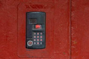 Eski boyalı kırmızı çelik yüzey üzerinde, yakın çekim için dijital ekran ve rFid sensörü olan bir dahili telefon.